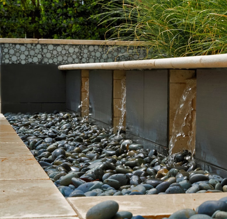 Water feature with river rock by Studio W