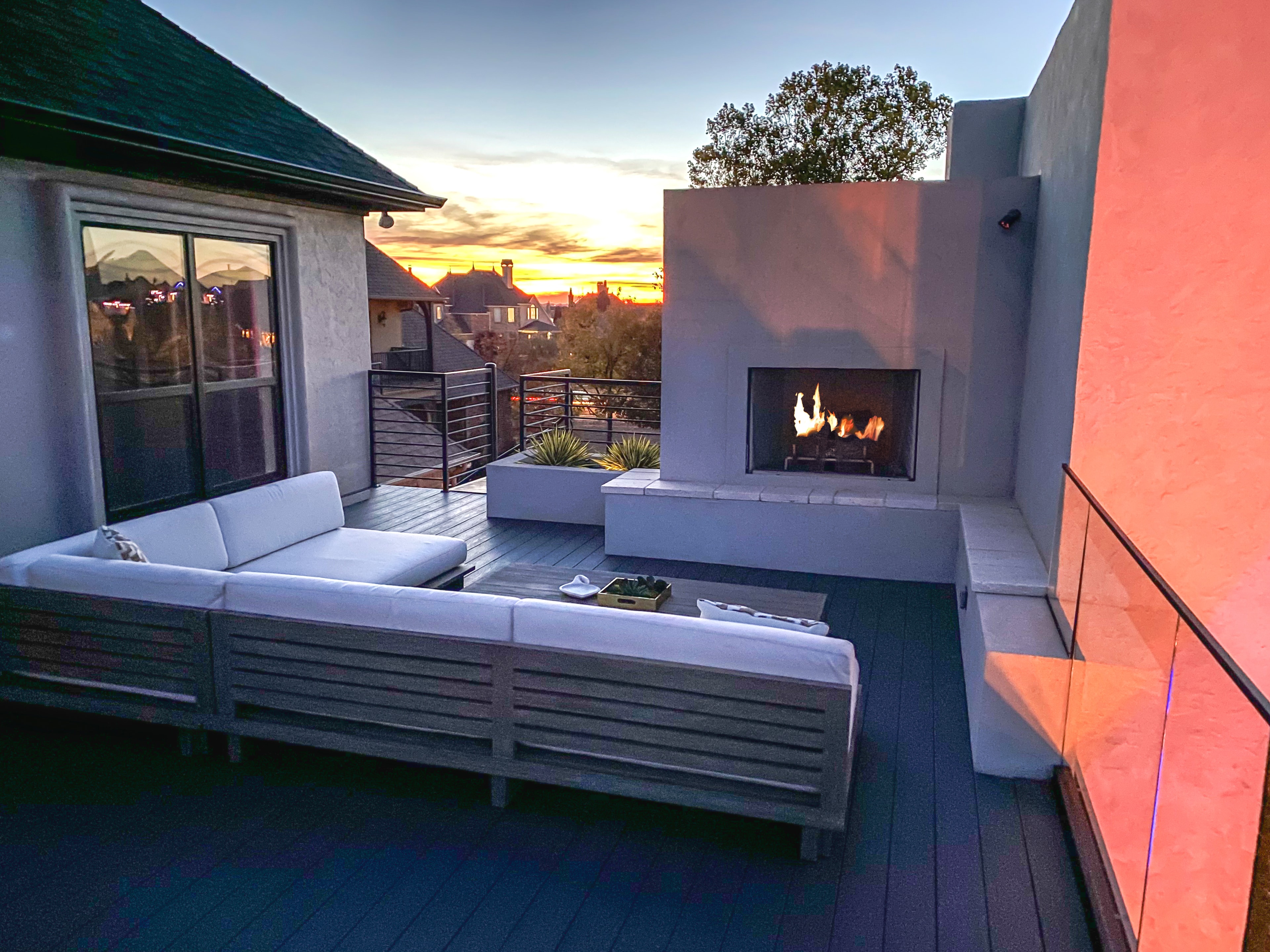 Rooftop terrace with fireplace at sunset by Studio W