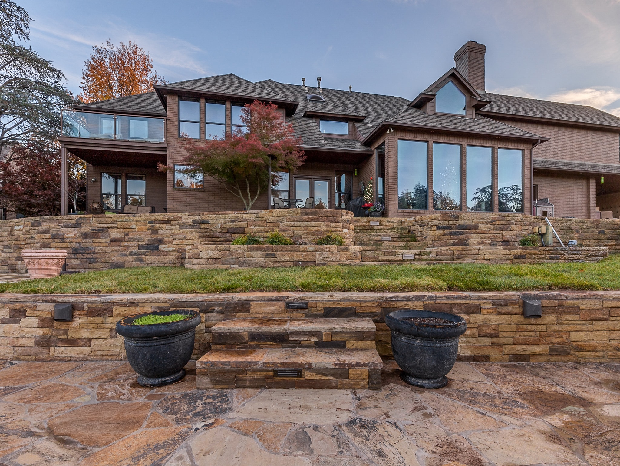 Stonebridge Drive terraced stone retaining walls with flagstone patio and Japanese maple in autumn