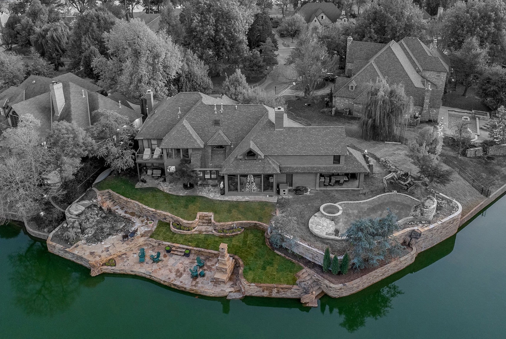 Colorized aerial of Stonebridge Drive waterfront property with stone retaining walls and patio