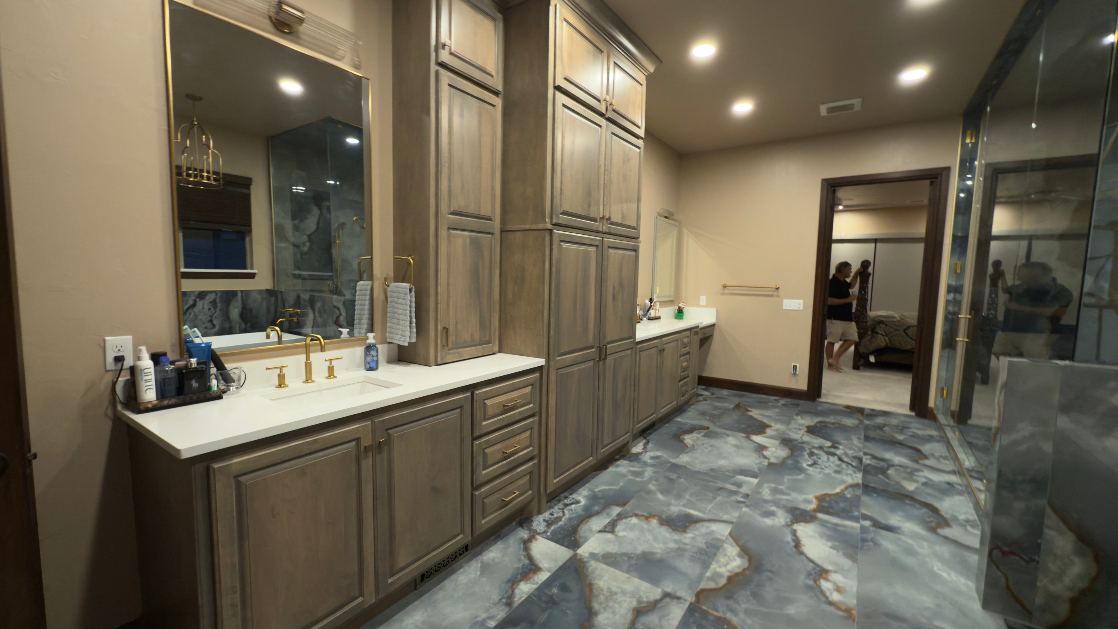 Master bath double vanity with custom cabinetry, white quartz countertops, and gold hardware