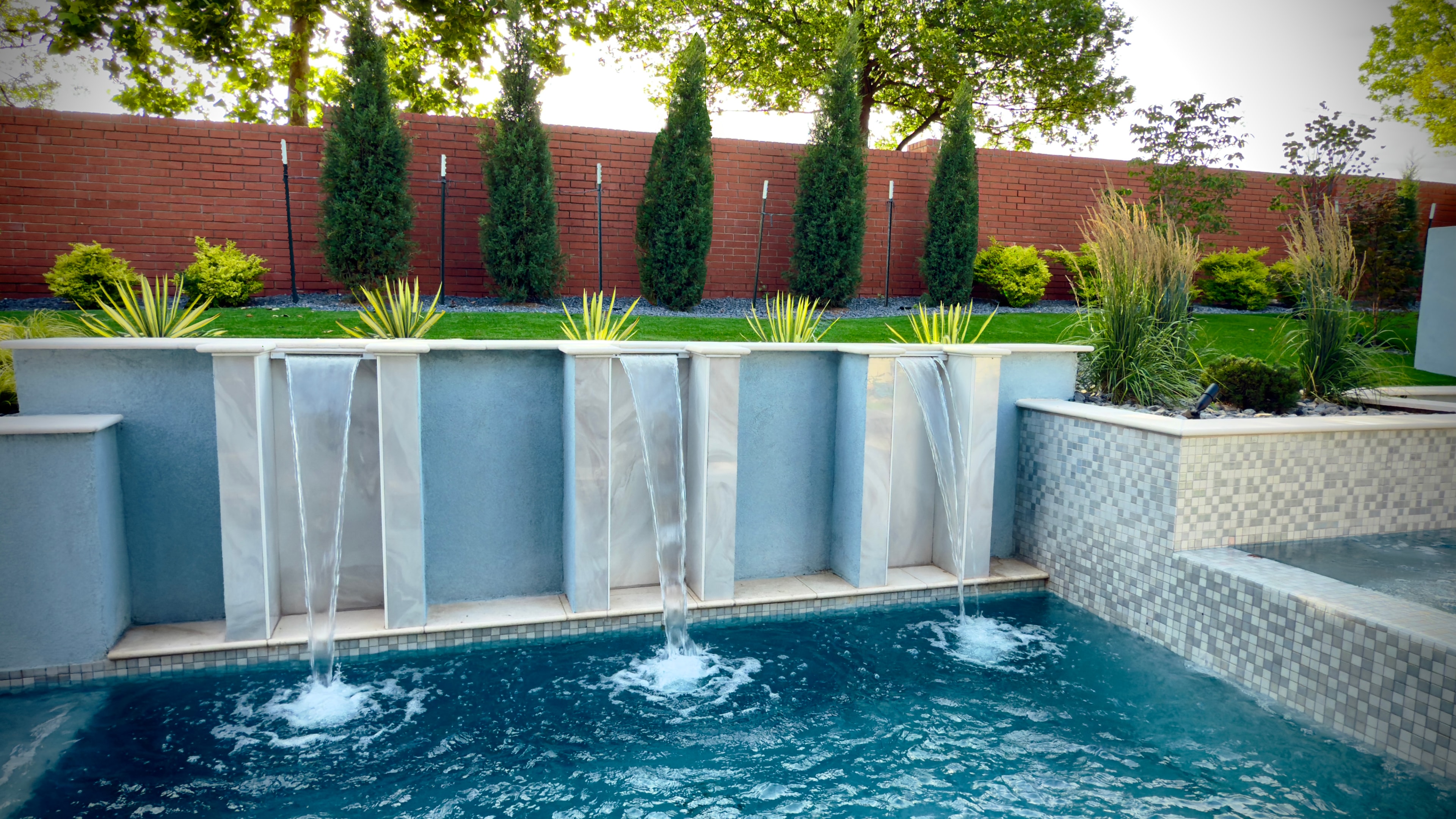 Modern pool with sheet waterfall and tile accents