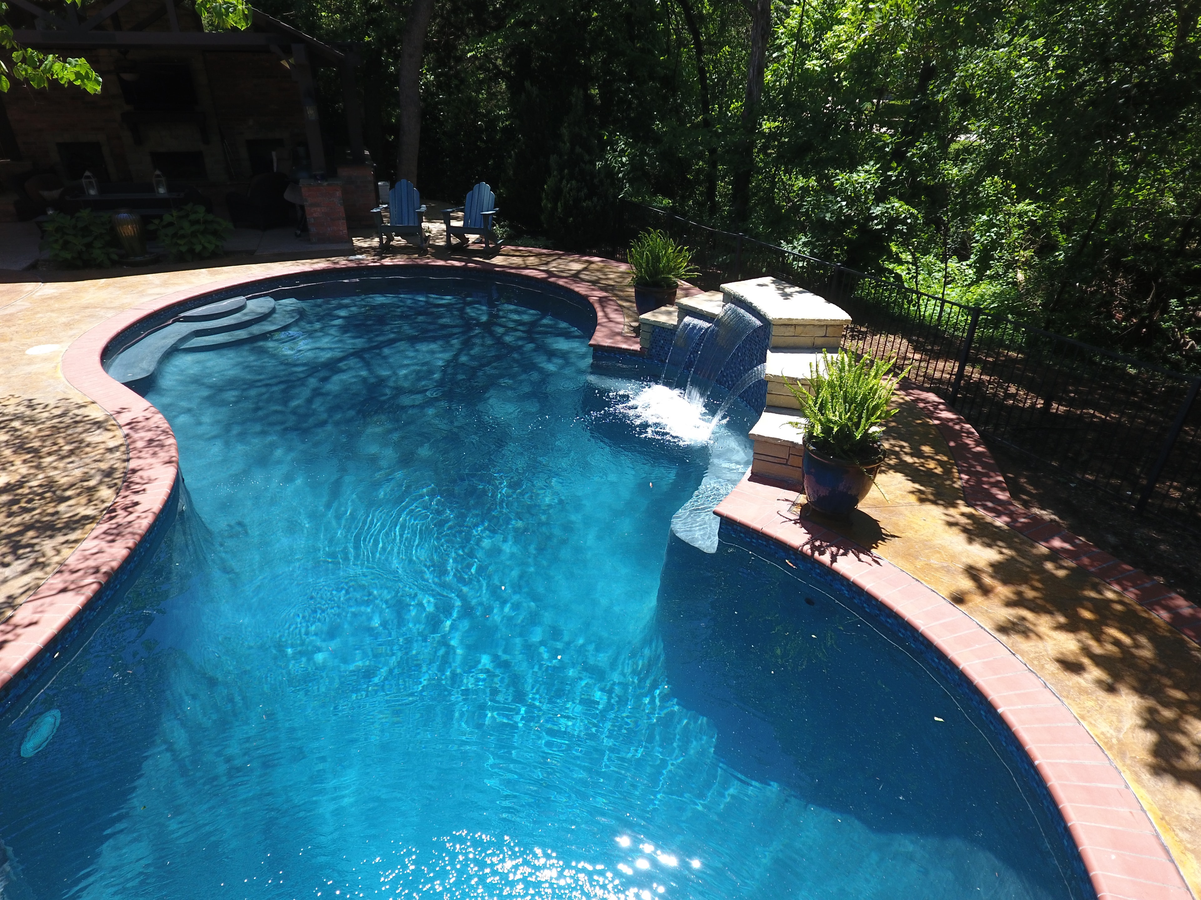 Residential pool with waterfall feature and outdoor seating